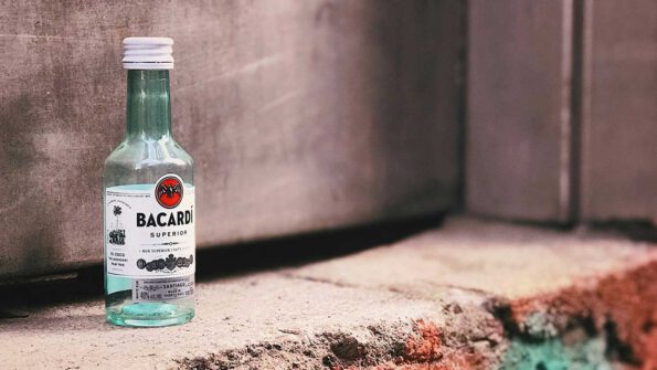 Kleine Flasche Bacardi Rum auf einer Mauer